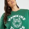 Camiseta 'Stranger Things' 'Hawkins' Con Sisa Baja - HOJA VERDE -Zalaris Tienda camiseta stranger things hawkins con sisa baja hoja verde ame70 1 frb1